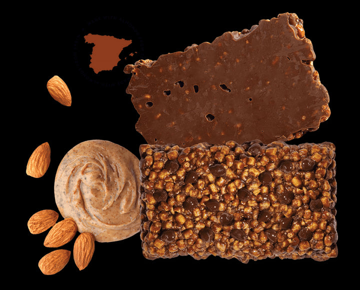 Arrangement of the bar surrounded by almonds and almond butter with a stamp showing the almonds are from Spain