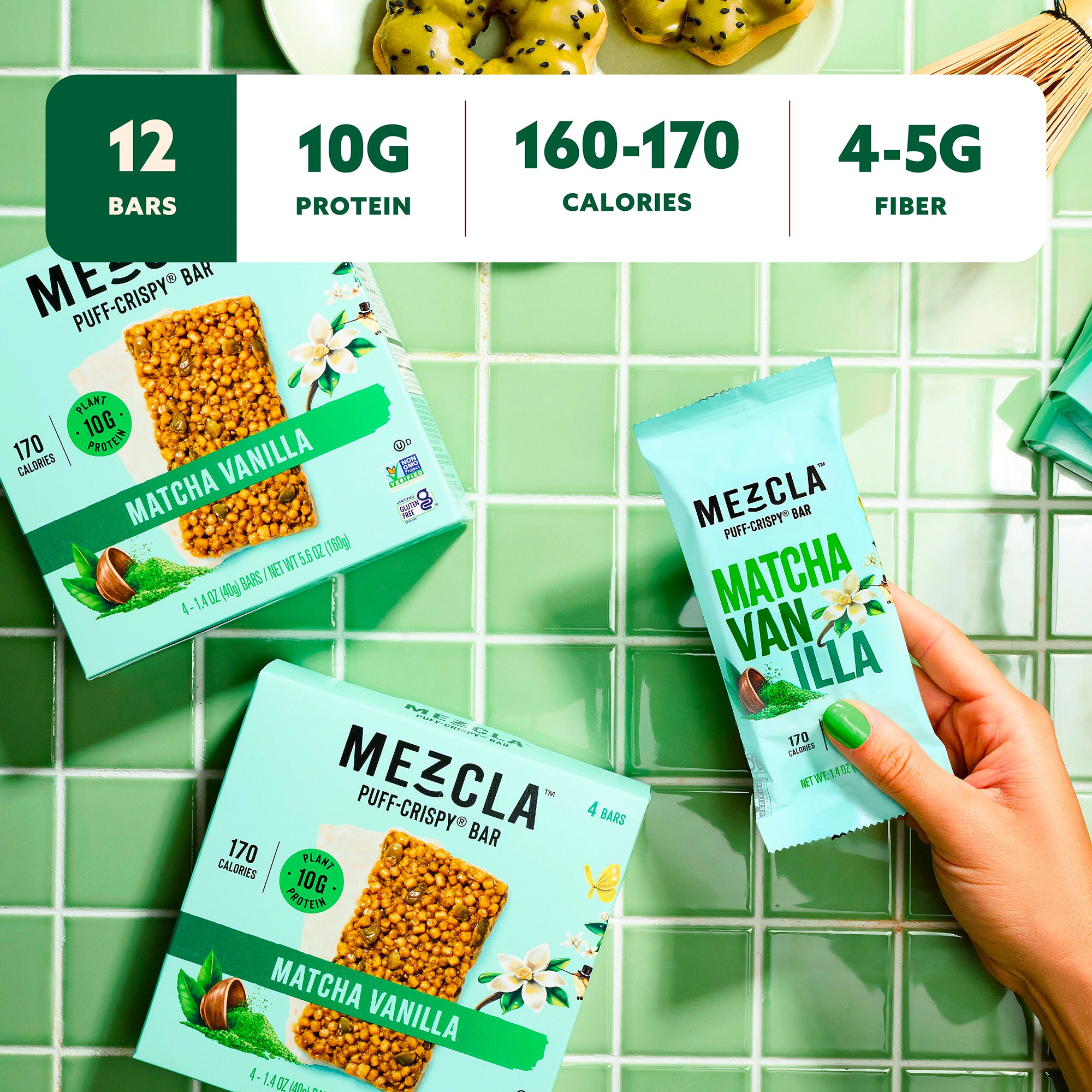 Hand holding Mezcla Matcha Vanilla protein bar with green packaging on tiled background, showing nutritional info