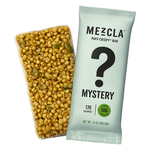 Mezcla mystery flavor protein bar in light green wrapper with question mark, shown alongside unwrapped bar revealing golden puffed grains and green pieces