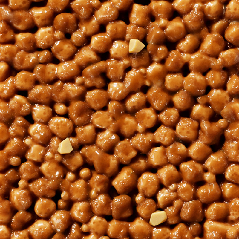 Glazed caramelized walnuts with honey coating and scattered almond slivers, close-up view showing glossy amber texture