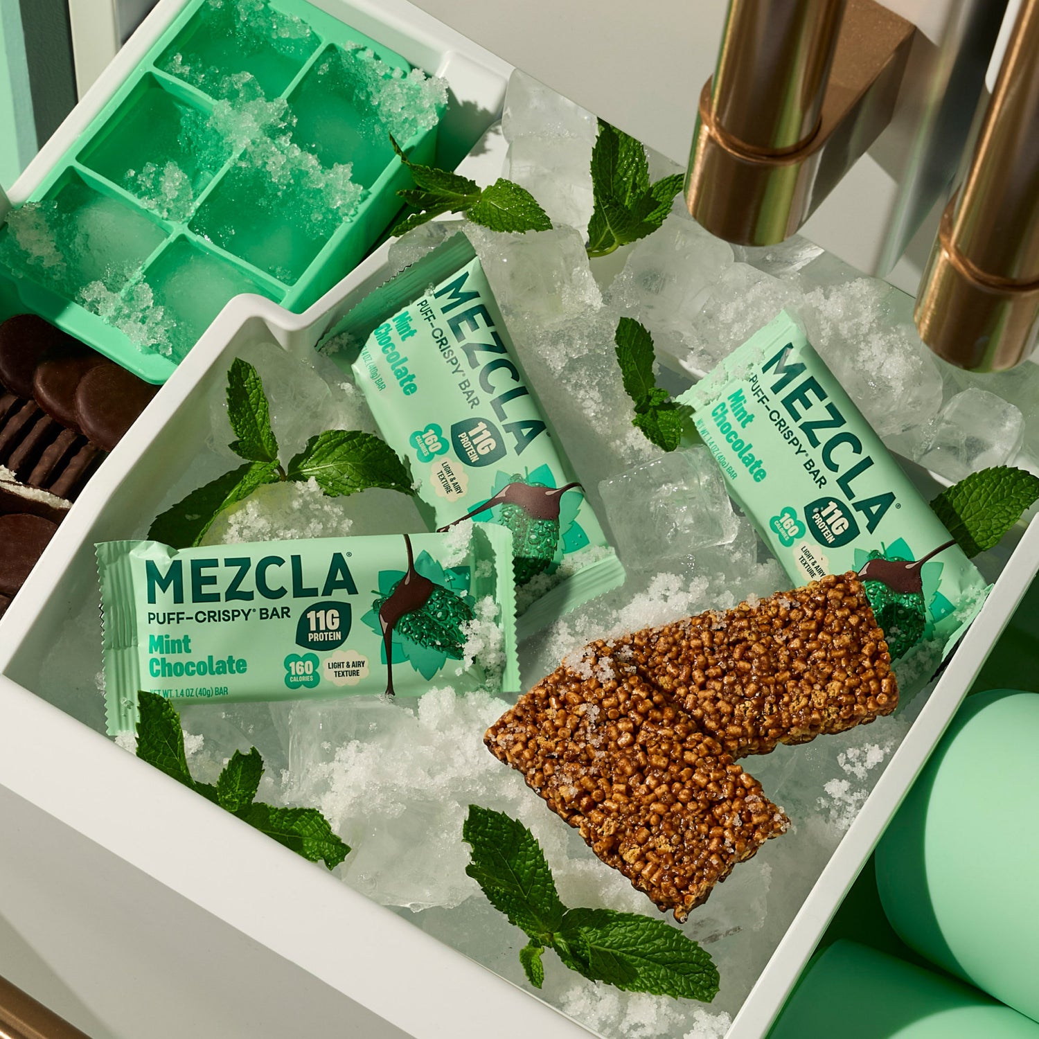 MEZCLA Mint Chocolate protein bars on ice with fresh mint leaves in white tray, green ice cube mold visible
