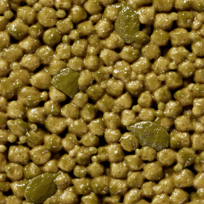 Close-up of glossy green mung beans or split peas with wet, shiny surface texture
