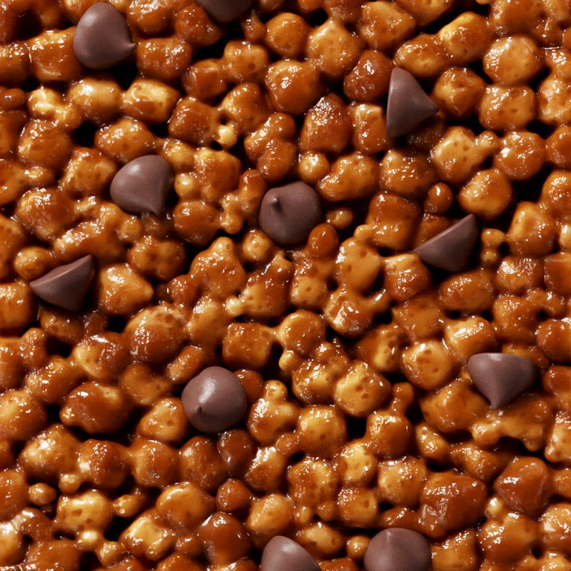 Glossy caramel-coated nuts and chocolate chips mixed together, creating a rich golden-brown confection with dark chocolate accents.